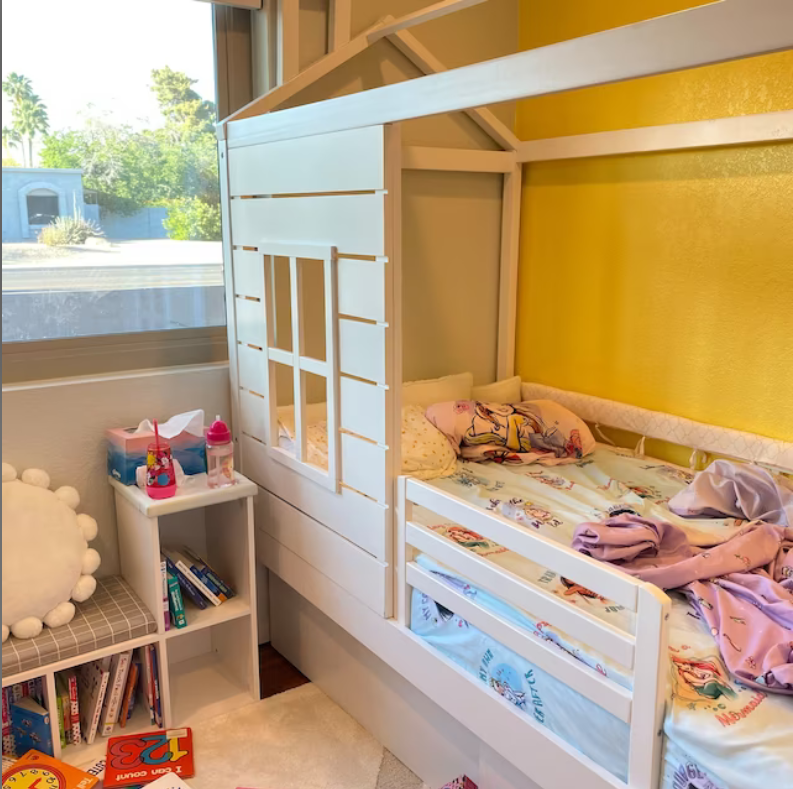 White wooden toddler bed rail attached to a cot